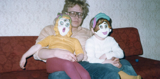 Jussi-ja-pellet_2 Jussi Hallikainen, sylissä kaksi lasta pellenaamareissa.