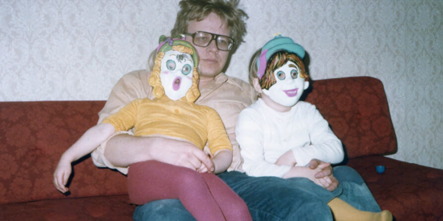 Jussi Hallikainen, sylissä kaksi lasta pellenaamareissa.